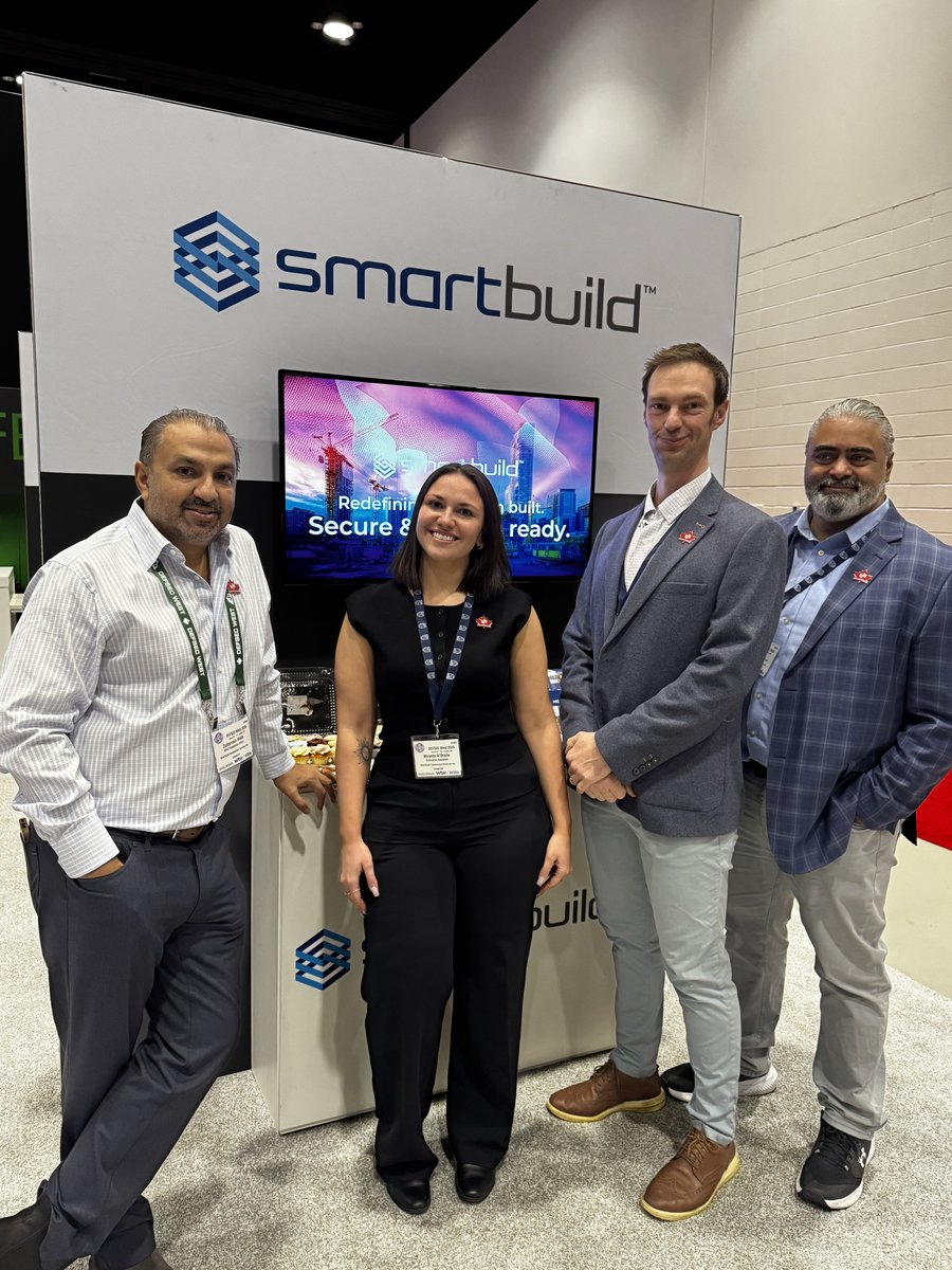Three SMARTBUILD team members at the company booth at a trade show