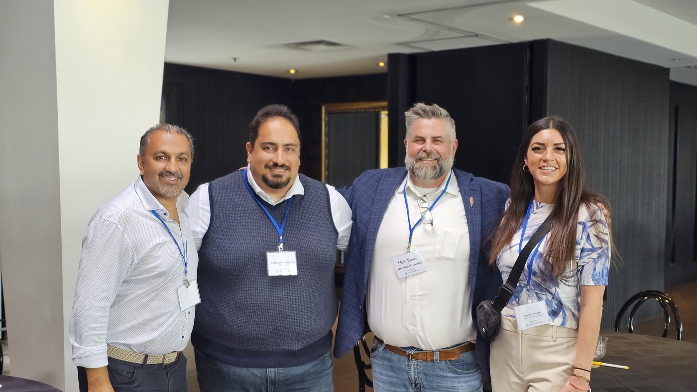 Zulq Malik with three industry contacts at a conference