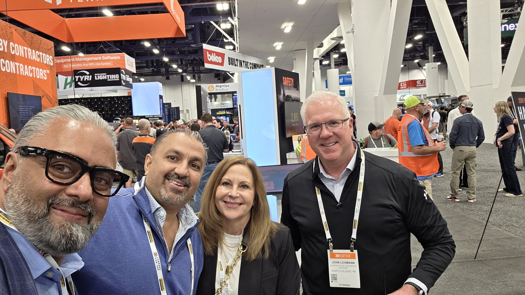 Zulq Malik and three partners together on the floor at a construction trade show